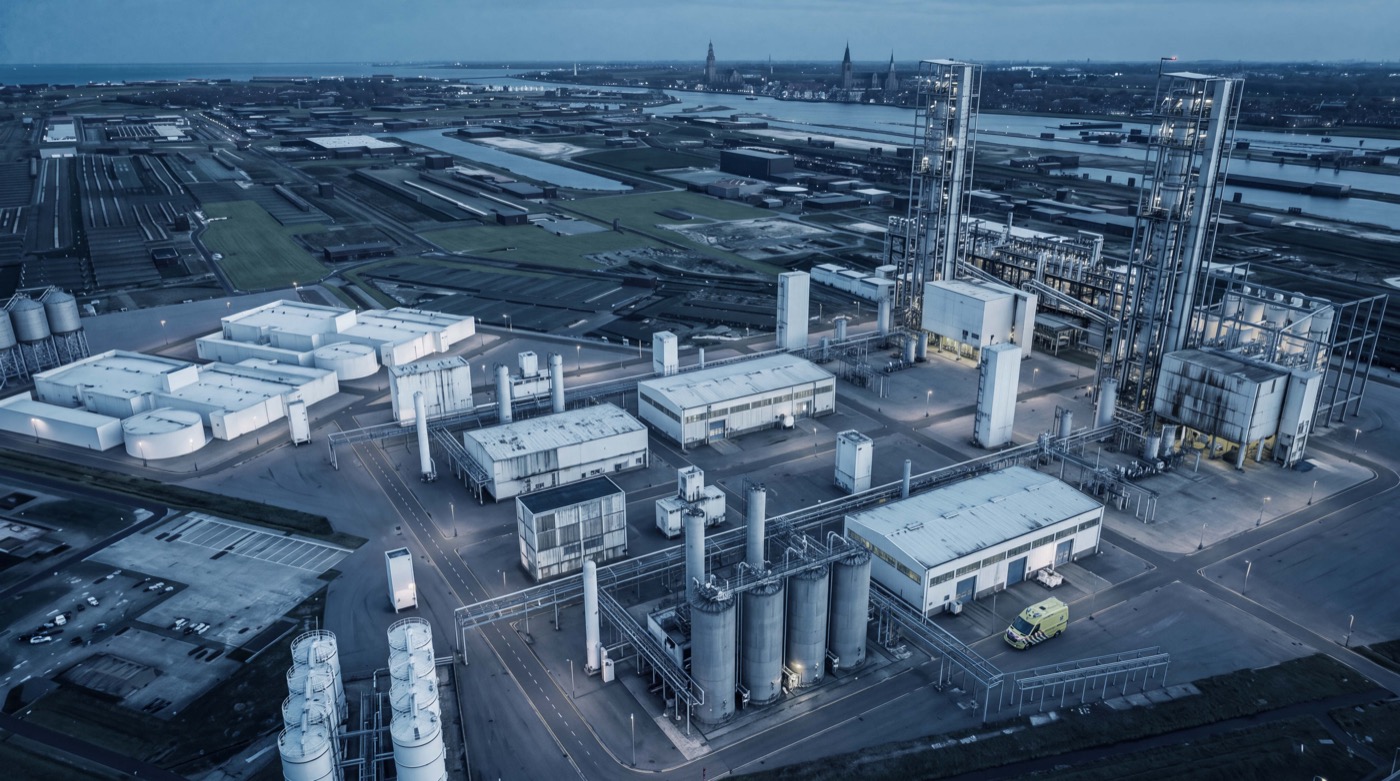Aerial view of a chemical plant at dusk with an ambulance on site